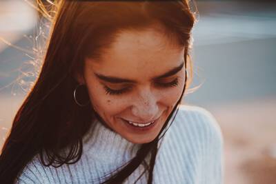 Mulher sorrindo, representando a importancia da autoestima e do autocuidado para a saude mental e bem-estar.