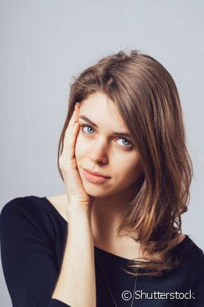 Mulher jovem com acne no rosto, representando por que a acne e comum na adolescencia e como trata-la adequadamente.