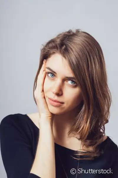 Mulher jovem com acne no rosto, representando por que a acne e comum na adolescencia e como trata-la adequadamente.