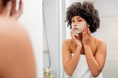 Mulher aplicando produtos de skincare no seu rosto