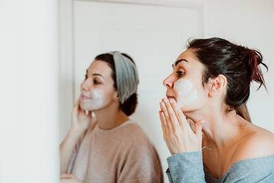 Mulheres fazendo skincare em frente ao espelho com argila branca, um ingrediente natural que purifica e suaviza a pele.