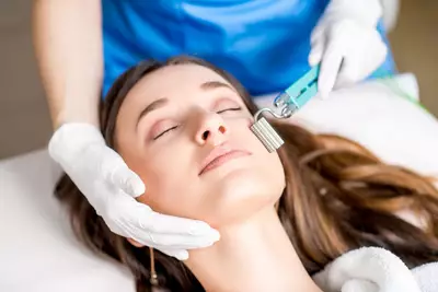 Procedimento de microagulhamento sendo realizado no rosto de uma mulher para estimular a producao de colageno e reduzir cicatrizes e rugas.