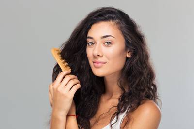 Mulher com doencas do couro cabeludo penteando o cabelo