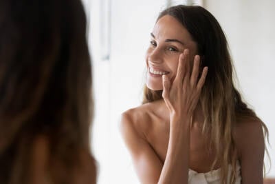 Mulher fazendo massagem facial, questionando se a pratica realmente e benefica para a pele.