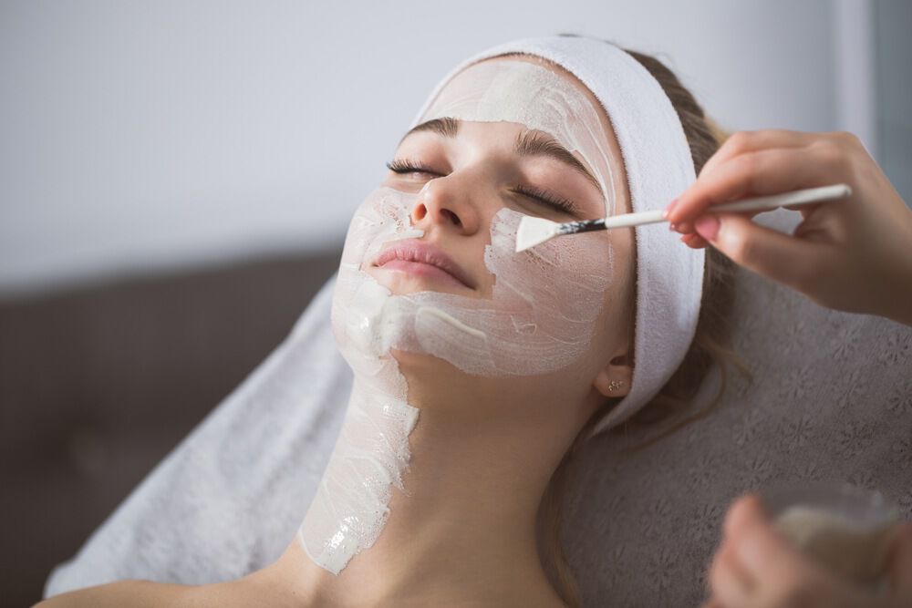 Mulher realizando peeling no rosto para clarear manchas e rugas