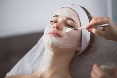 Mulher realizando peeling no rosto para clarear manchas e rugas