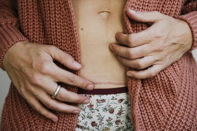 Maos femininas sob a barriga