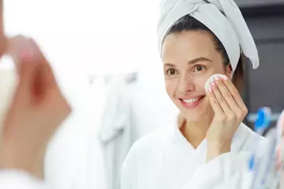 Pessoa aplicando produtos contendo acido salicilico e LHA para tratamento da pele oleosa