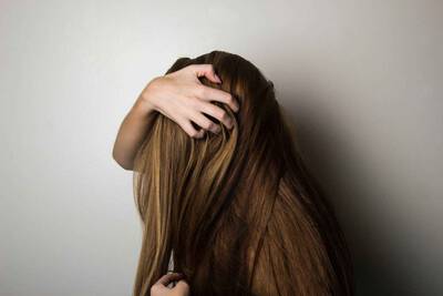 Mulher cuidando da queda de cabelo, seguindo 4 dicas para evitar que os fios caiam.