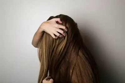 Mulher cuidando da queda de cabelo, seguindo 4 dicas para evitar que os fios caiam.
