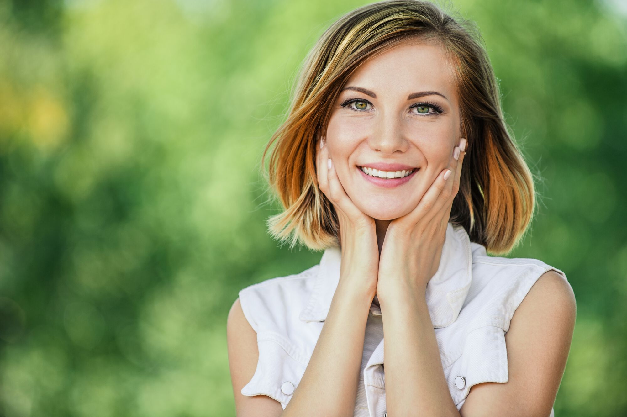 Mulher sorrindo com maos no rosto