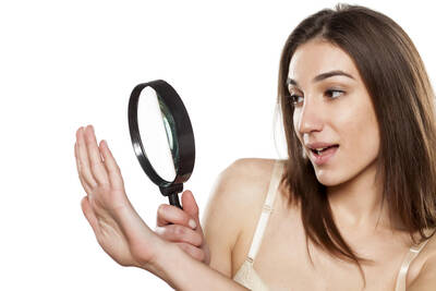 Mulher buscando manchas brancas na unha