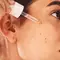 Mulher aplicando serum com PDRN no rosto