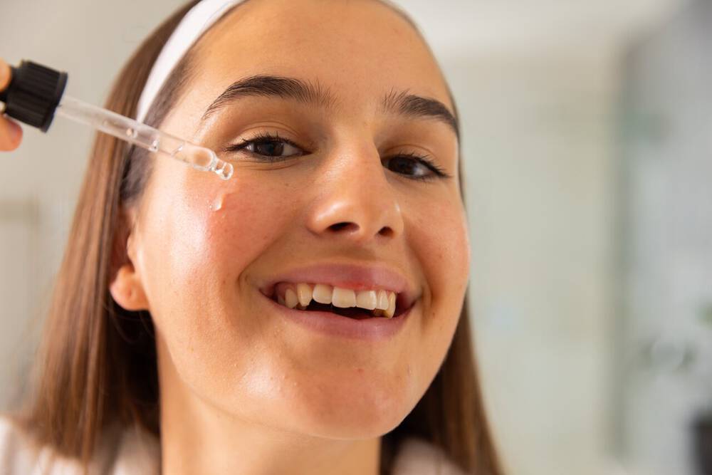 Mulher passando hidratante facial para pele sensivel