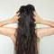 Jovem mulher tocando o couro cabeludo para cuidar do cabelo