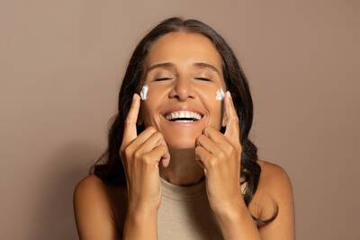 Mulher alegre usando bioestimulador de colageno