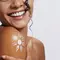 Mulher sorridente com protetor solar fluido no ombro