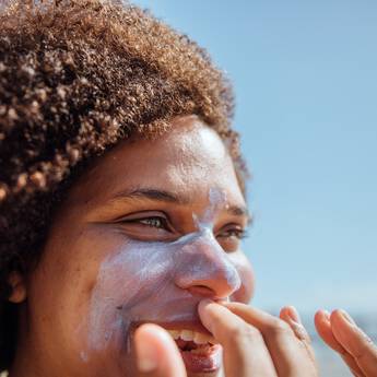 Mulher passando protetor solar