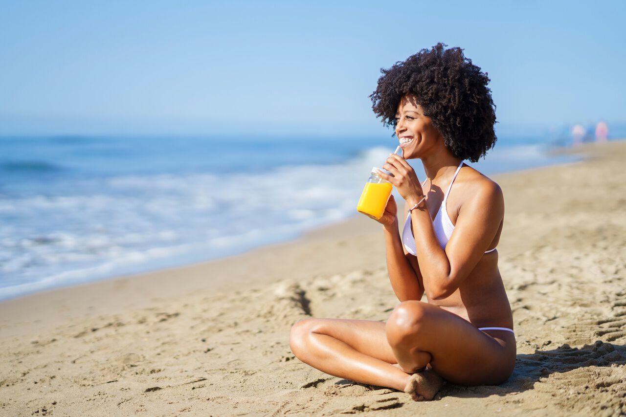 Mulher com cabelos crespos na praia