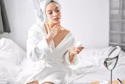 Mulher aplicando creme para colo e pescoco