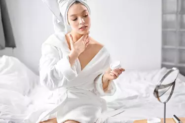 Mulher aplicando creme para colo e pescoco