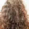 Mulher de costas com frizz no cabelo cacheado