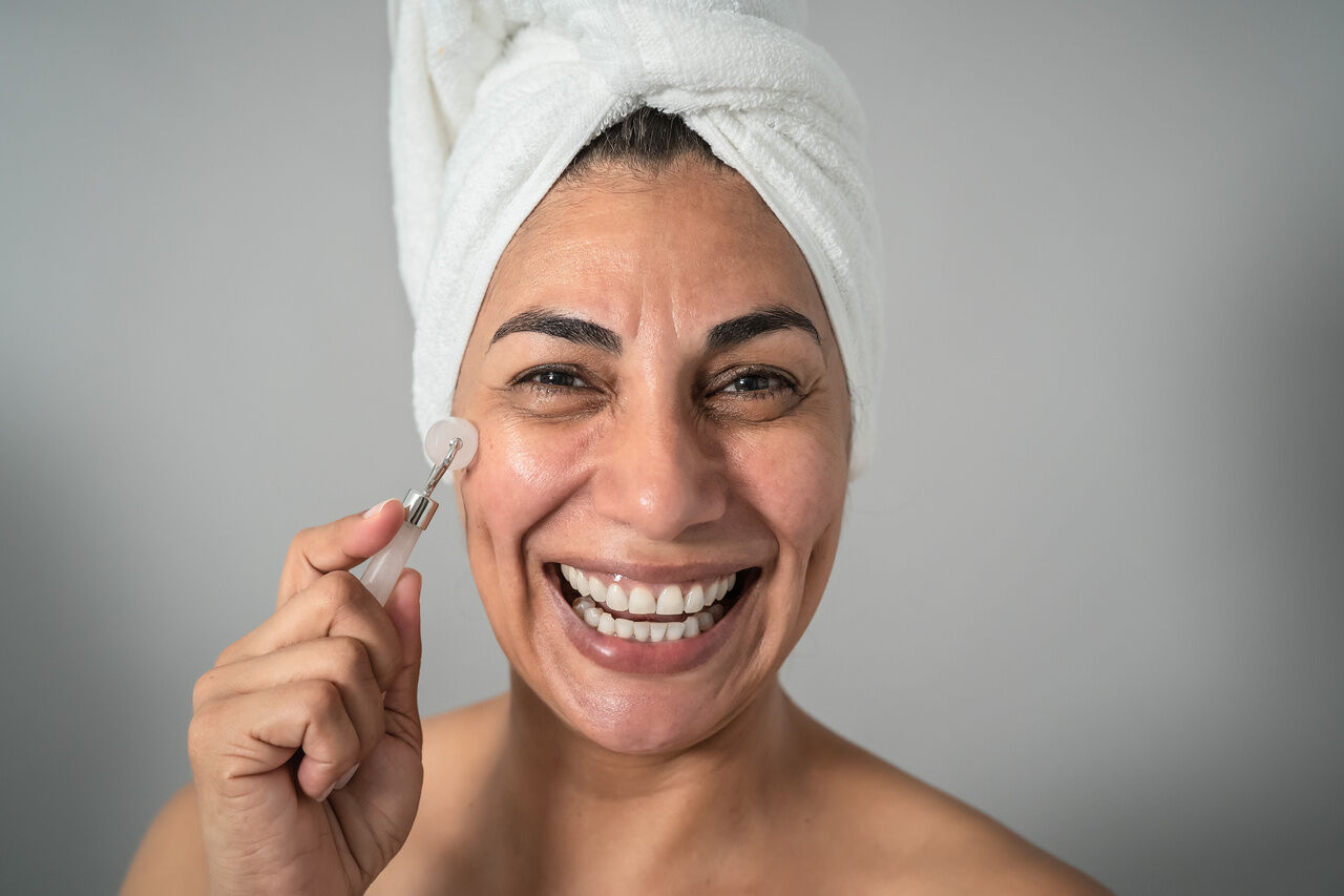 Mulher madura sorrindo, com a pele visivelmente cuidada, representando o tema de envelhecimento da pele