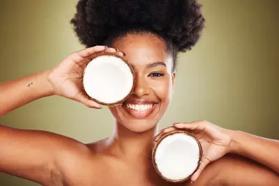 Mulher utilizando oleo de coco, um ingrediente natural com propriedades hidratantes e nutritivas para a pele e cabelos.