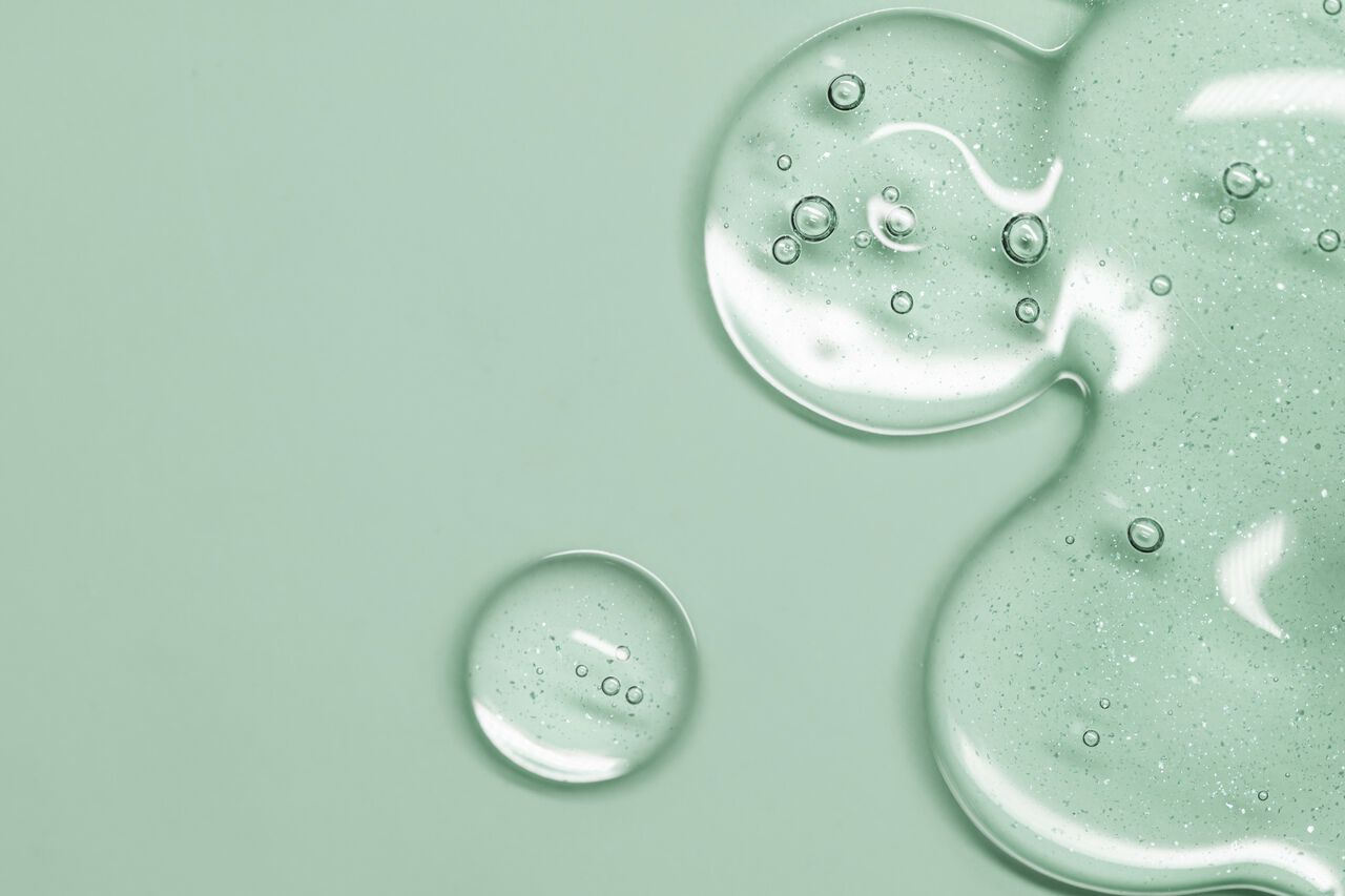 Gotas de gel de limpeza em fundo verde