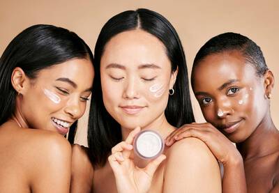 Foto de tres mulheres com diferentes tons de pele aplicando creme facial com colageno para manter