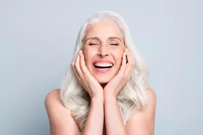Mulher sorrindo com rosto livre de manchas apos utilizar suplemento de colageno em po