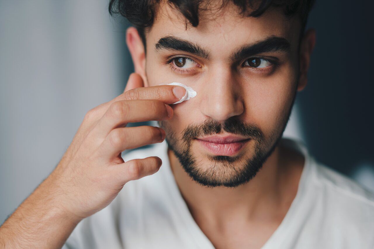 Homem passando hidratante facial masculino