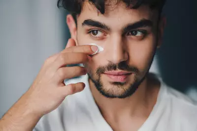 Homem passando hidratante facial masculino