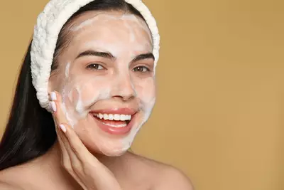 Mulher lavado o rosto com espuma de limpeza air foam da Cerave