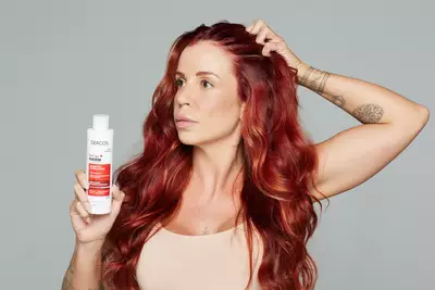 Mulher feliz com cabelo saudavel por conta do uso de vitamina para cabelo