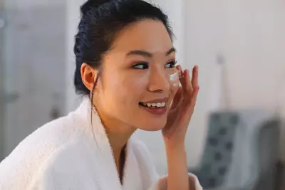 Mulher aplicando produto com centella asiatica