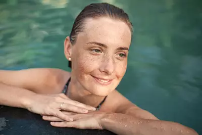 Mulher na piscina com manchas solares no rosto