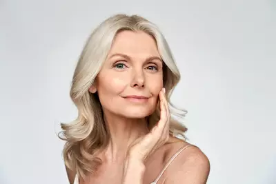 Mulher madura com pele reluzente apos procedimento de rejuvenescimento facial