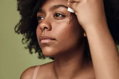 Mulher jovem aplicando melhor serum para pele oleosa