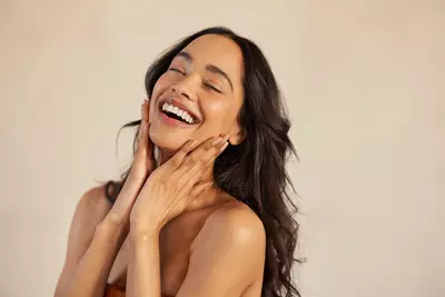 Mulher feliz tocando seu rosto limpo
