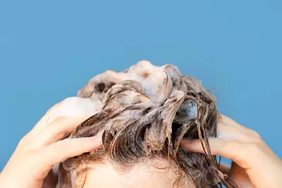 Mulher aplicando shampoo e condicionador no cabelo