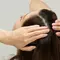 Mulher passando shampoo para tirar caspa do cabelo