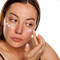 Mulher aplicando creme para manchas no rosto