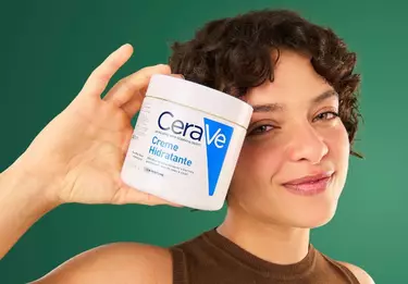 Mulher jovem segurando Cicaplast Baume B5+