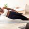 Mulher negra sorridente em prancha lateral sobre tapete de yoga