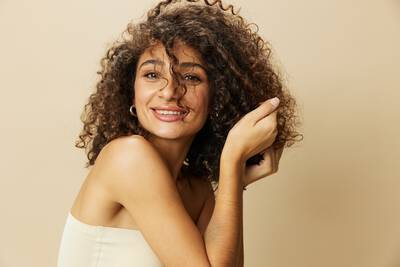 Mulher apos realizar nutricao capilar em seu cabelo cacheado