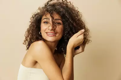 Mulher apos realizar nutricao capilar em seu cabelo cacheado