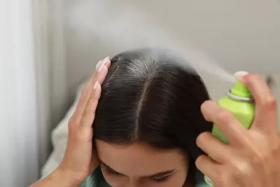Pessoa aplicando shampoo a seco