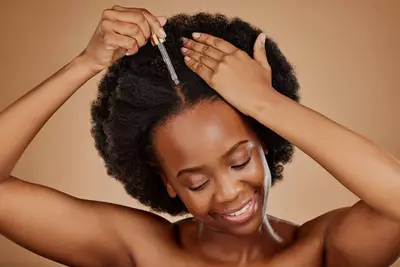 Mulher aplicando oleo de argan nos cabelos