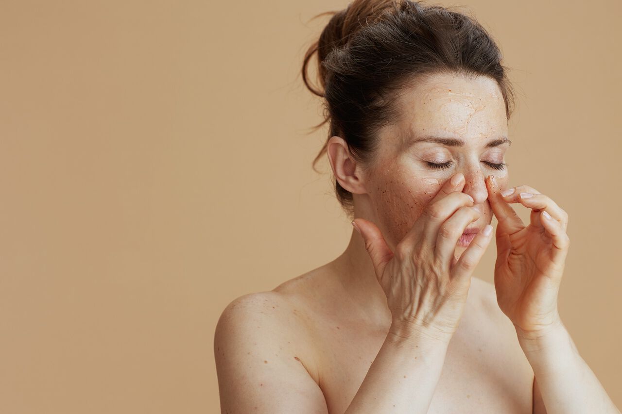 Mulher realizando esfoliacao facial